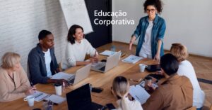 Sete pessoas sentadas ao redor de uma mesa de escritório representando educação corporativa nas empresas