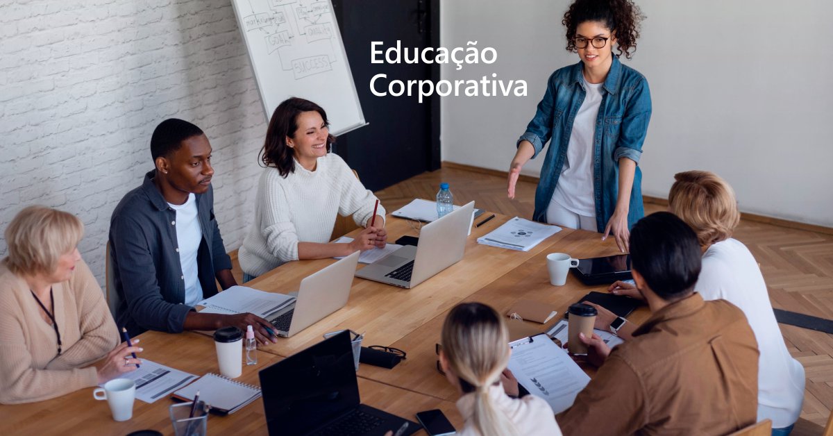 Sete pessoas sentadas ao redor de uma mesa de escritório representando educação corporativa nas empresas